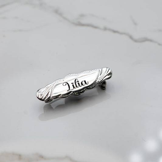 Silver brooch with 'Lilia' engraved on a marble surface